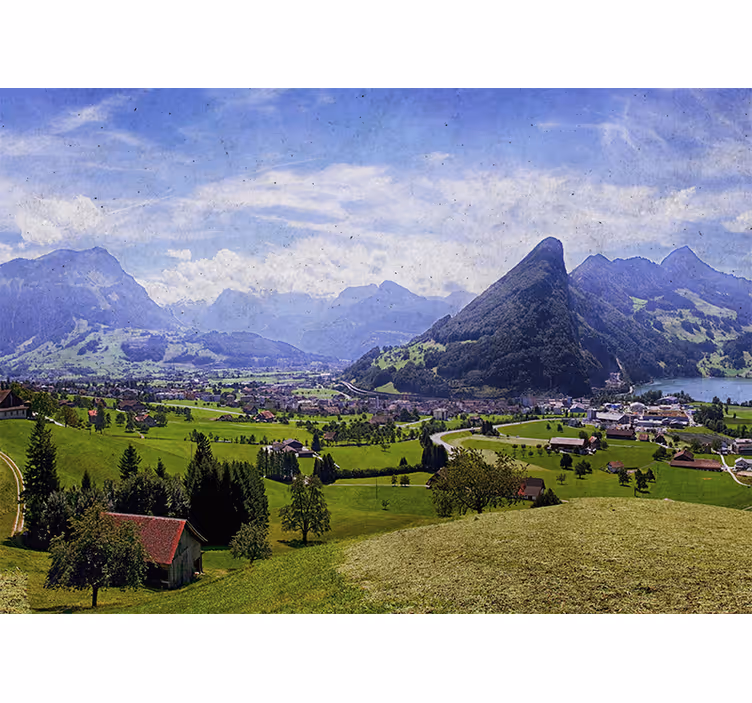 Toile fenêtre salon maisons sur champ vert montagnes - TenStickers